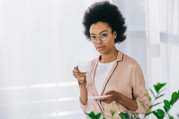 Attraente donna d'affari africana americana che beve caffè in ufficio — Foto stock