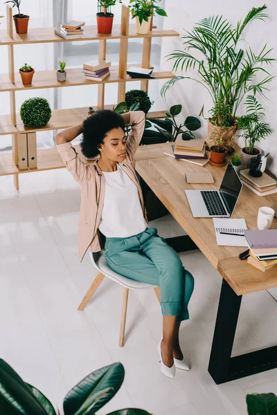 High angle view of beautiful african american businesswoman resting on chair in office — Stock Photo