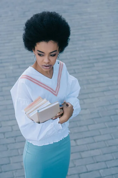 Beautiful african american businesswoman standing with books on street — Stock Photo