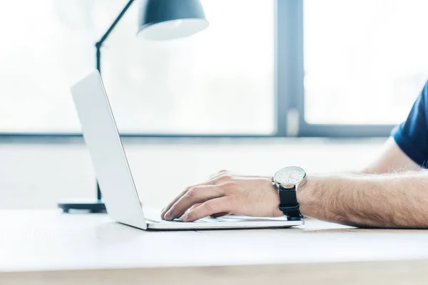 Partial view of person using laptop at workplace — Stock Photo