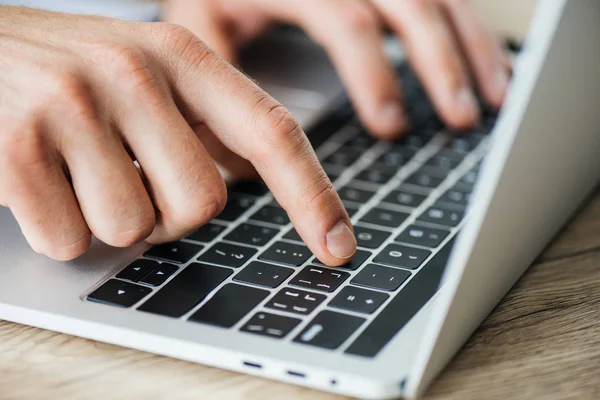 Close-up partial view of person typing on laptop, selective focus — Stock Photo