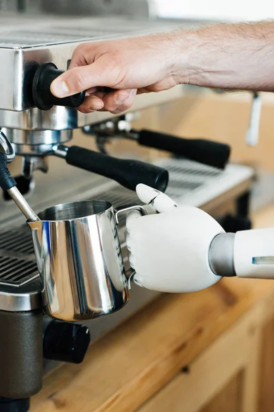 Крупним планом роботизована рука і рука людини за допомогою кавоварки — стокове фото