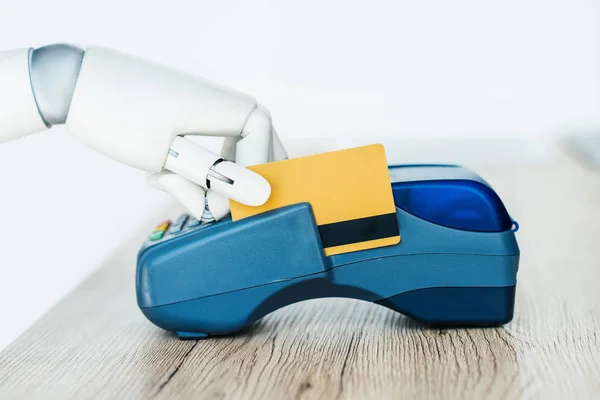 Close-up view of robot holding credit card and using payment terminal — Stock Photo