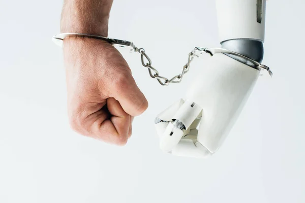 Close-up view of human hand and hand of robot in handcuffs isolated on white — Stock Photo