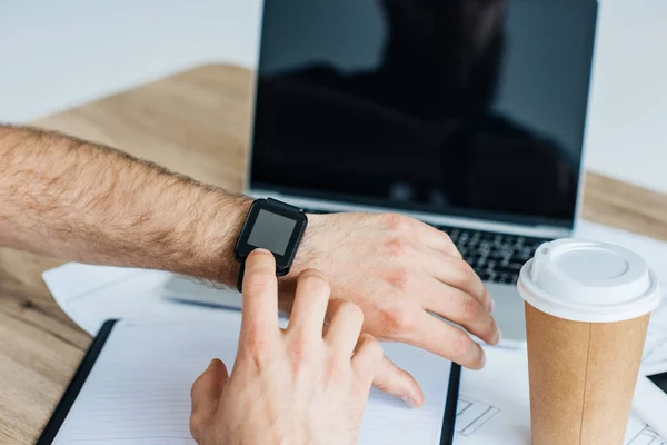 Gros plan vue partielle de la personne qui utilise smartwatch sur le lieu de travail — Photo de stock