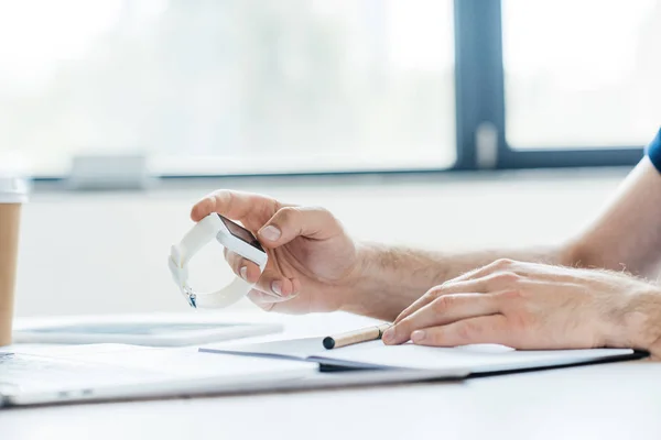 Cropped shot of person using smartwatch at workplace — Stock Photo