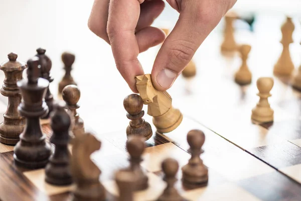 Close-up partial view of human hand playing chess — Stock Photo