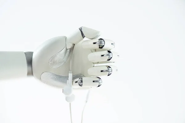 Close-up view of robotic hand holding earphones isolated on white — Stock Photo