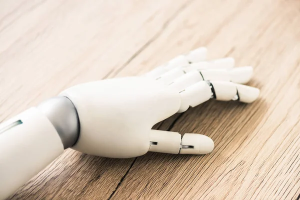 Close-up view of hand of robot on wooden surface — Stock Photo