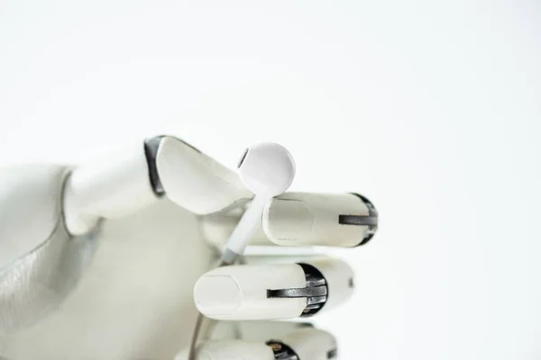 Vista de primer plano del robot sosteniendo auriculares aislados en blanco - foto de stock