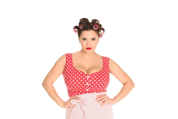Angry plus size housewife in red dress with curlers in hair isolated on white — Stock Photo
