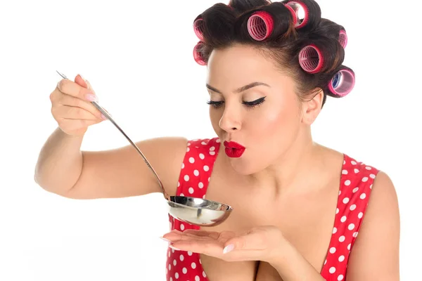 Close-up portrait of plus size housewife cooking and blowing on ladle isolated on white — Stock Photo