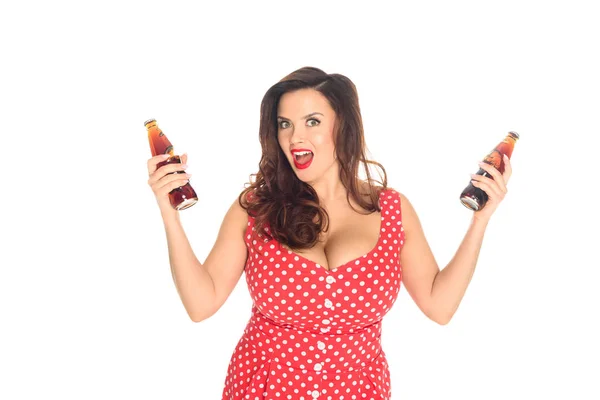 Excited plus size woman with bottles of soda looking at camera isolated on white — Stock Photo