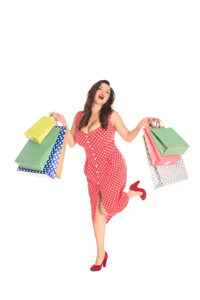 Feliz más tamaño mujer sosteniendo coloridas bolsas de compras aisladas en blanco - foto de stock