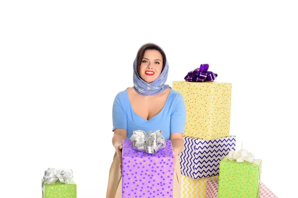 Hermosa pin up mujer sosteniendo caja de regalo y sonriendo a la cámara aislada en blanco - foto de stock