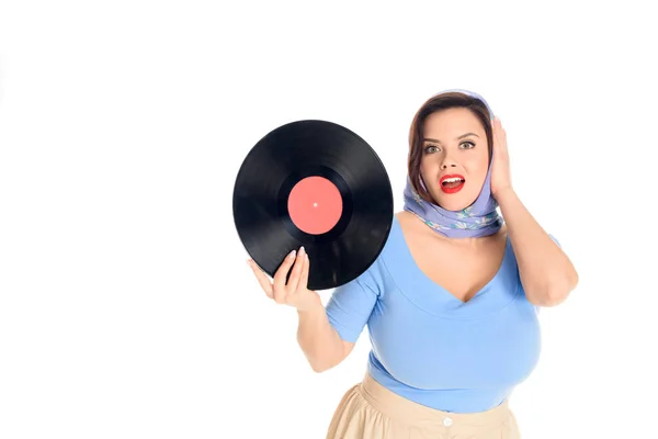 Beautiful surprised pin up girl holding vinyl record and looking at camera isolated on white — Stock Photo