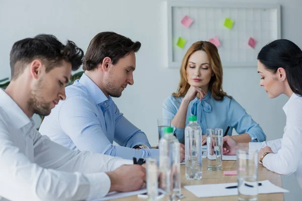 Selective focus of focused business people at workplace in office — Stock Photo