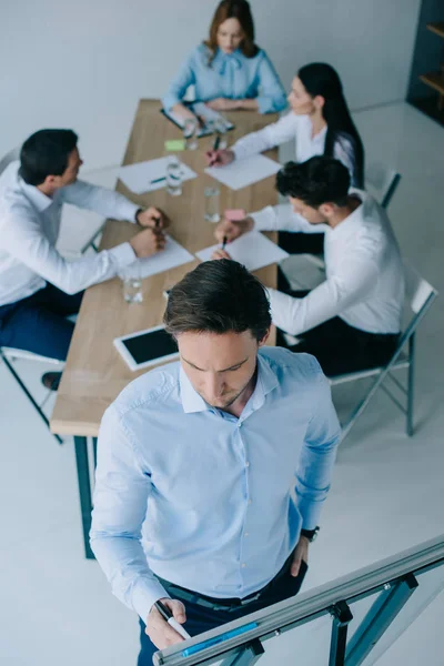 Вибірковий фокус бізнесмена в білій дошці і колег на робочому місці в офісі — стокове фото