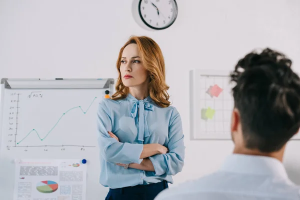 Selective focus of pensive businesswoman at white board and colleague in office — Stock Photo