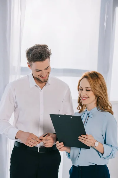 Portrait de collègues d'affaires souriants avec bloc-notes au bureau — Photo de stock