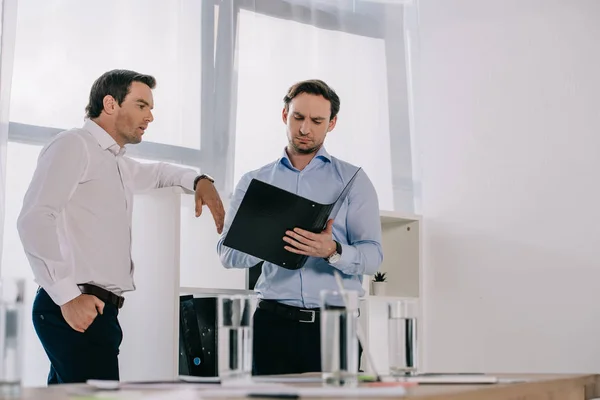 Empresarios con documentos en el lugar de trabajo en la oficina - foto de stock