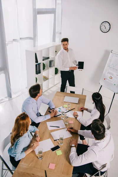 Visión de alto ángulo de los compañeros de trabajo de negocios que tienen formación empresarial en la oficina - foto de stock