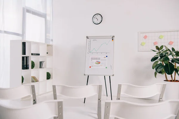 Weiße, leere Stühle und weißes Brett mit Grafik im Büro, Schulungskonzept — Stockfoto