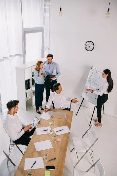 Visión de alto ángulo de los compañeros de trabajo de negocios que tienen formación empresarial en la oficina - foto de stock