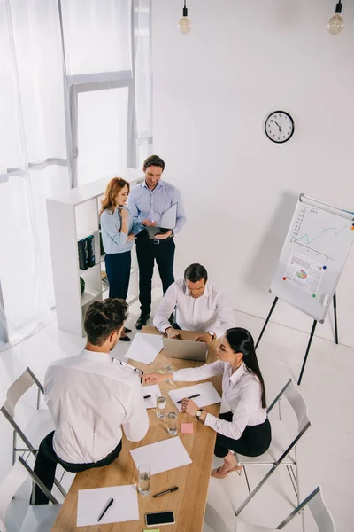 Visión de alto ángulo de los compañeros de trabajo de negocios que tienen formación empresarial en la oficina - foto de stock