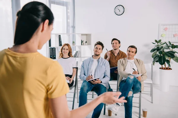 Enfoque selectivo de las personas de negocios que escuchan a la mentora durante la formación empresarial - foto de stock