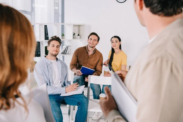 Vue partielle des gens d'affaires en vêtements décontractés ayant une formation en affaires au bureau — Photo de stock