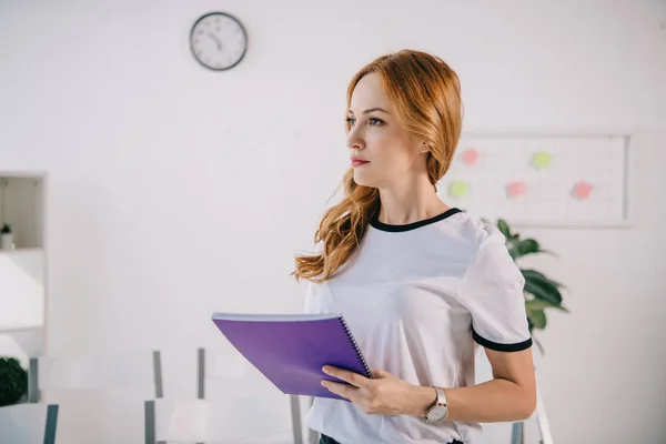 Side view of businesswoman in casual clothing with notebook in hands, business training concept — Stock Photo