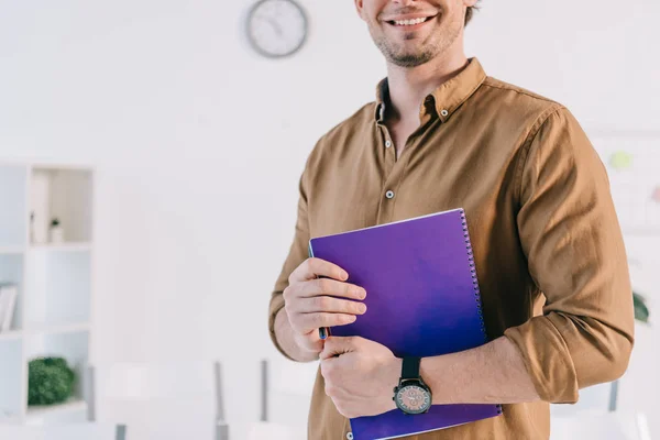 Cropped shot of smiling businessman in casual clothing with notebook n office, business training concept — Stock Photo