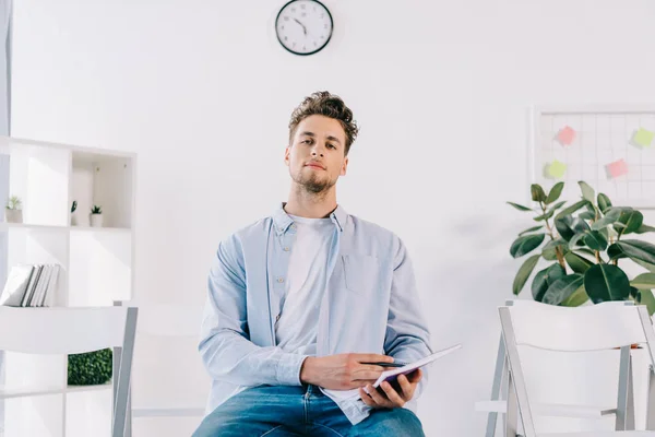 Homme d'affaires en vêtements décontractés avec ordinateur portable assis sur la chaise dans le bureau, concept de formation d'affaires — Photo de stock