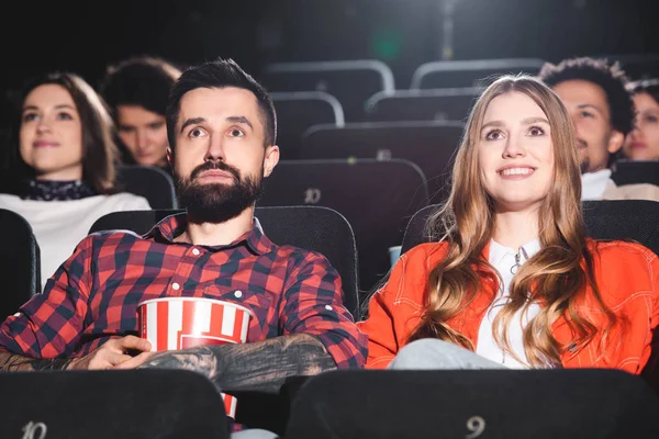 Bonito namorado e sorridente namorada assistindo filme no cinema — Fotografia de Stock