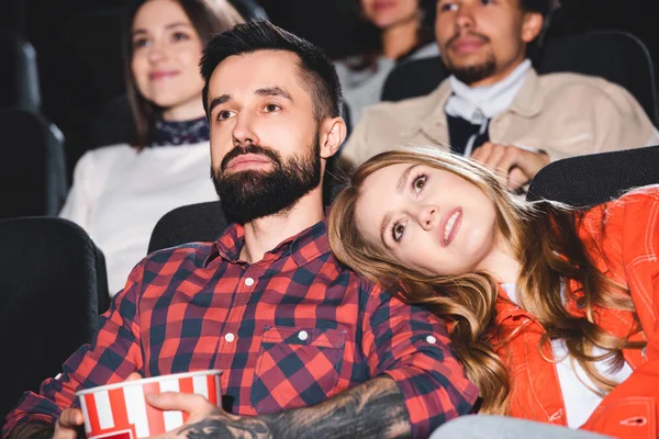 Attrayant copine couché sur l'épaule de beau petit ami et regarder un film au cinéma — Photo de stock