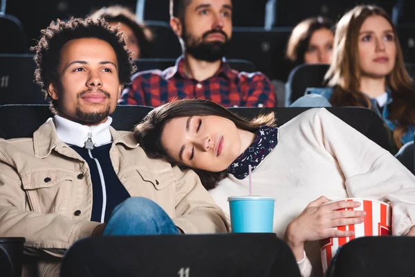 Focalizzazione selettiva della donna che dorme sulla spalla del suo amico afroamericano nel cinema — Foto stock