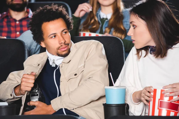 Homem americano africano atirando com câmera digital e olhando para seu amigo no cinema — Fotografia de Stock