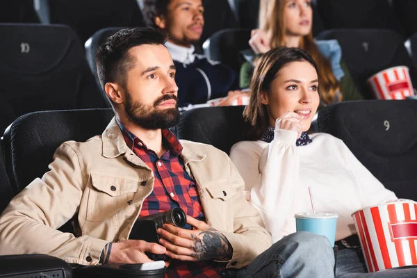 Foco seletivo de homem fotografar com câmera digital e assistir filme com amigo no cinema — Fotografia de Stock