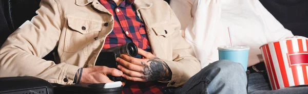 Panoramic shot of man shooting with digital camera in cinema — Stock Photo