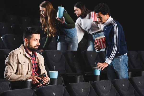 Selective focus of man shooting with digital camera and watching movie in cinema — Stock Photo