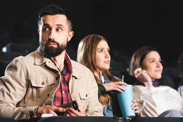 Selective focus of man shooting with digital camera and looking away in cinema — Stock Photo