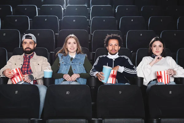 Amigos multiculturais sorrindo e assistindo filme no cinema — Fotografia de Stock