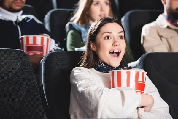 Selektiver Fokus einer lächelnden Frau mit Popcorn im Kino — Stockfoto