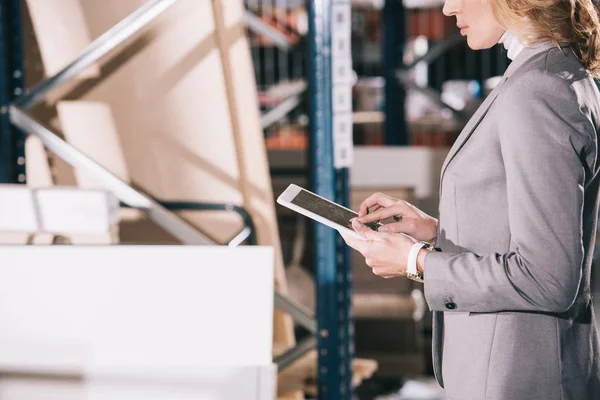Vue recadrée de femme d'affaires en utilisant une tablette numérique dans l'entrepôt — Photo de stock