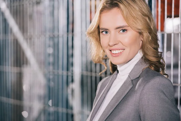 Attractive businesswoman smiling at camera in warehouse — Stock Photo