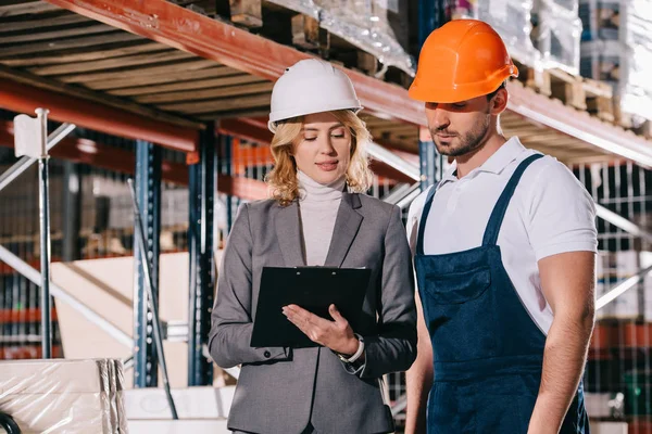 Concentrato imprenditore e magazziniere guardando appunti — Foto stock