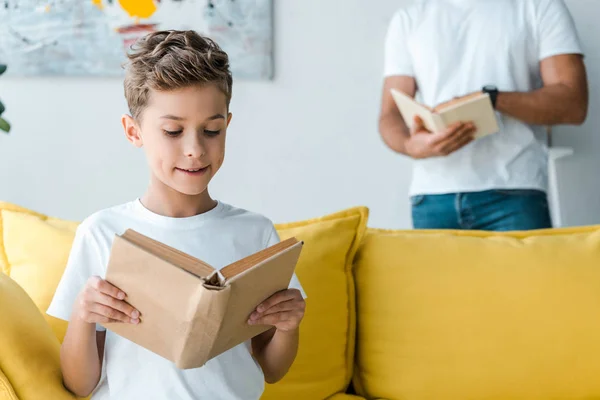 Abgeschnittene Ansicht von Vater und Sohn, die Bücher zu Hause halten — Stockfoto