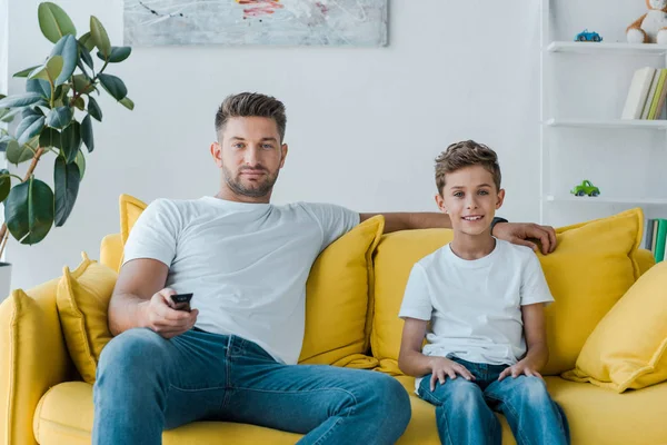 Schöner Vater und glücklicher Sohn vor dem Fernseher zu Hause — Stockfoto