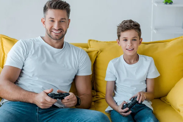 KYIV, UKRAINE - OCTOBER 2, 2019: happy father and son playing video game at home — Stock Photo